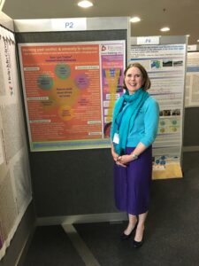 Researcher in front of her abstract poster